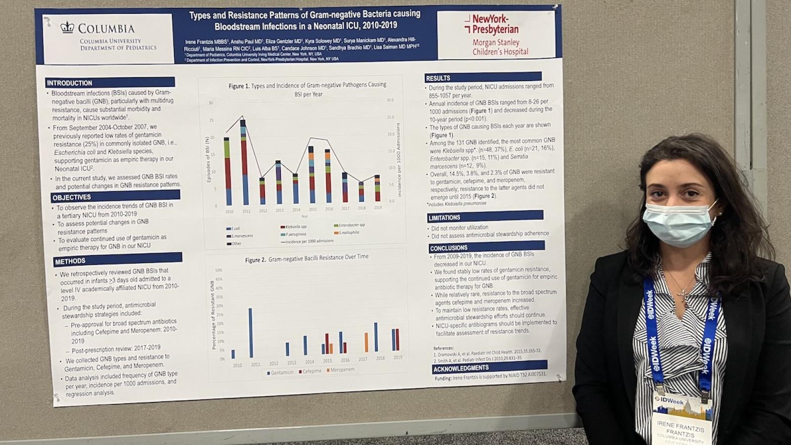 researcher in front of poster at conference