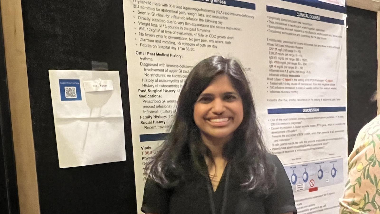 researcher in front of poster at conference