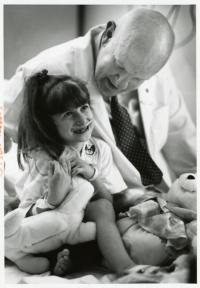 John Driscoll, MD sitting next to a little girl making her laugh