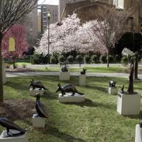 Garden with statues of animals and flowering trees.