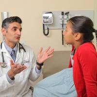 A doctor speaks with a girl in a doctor's office
